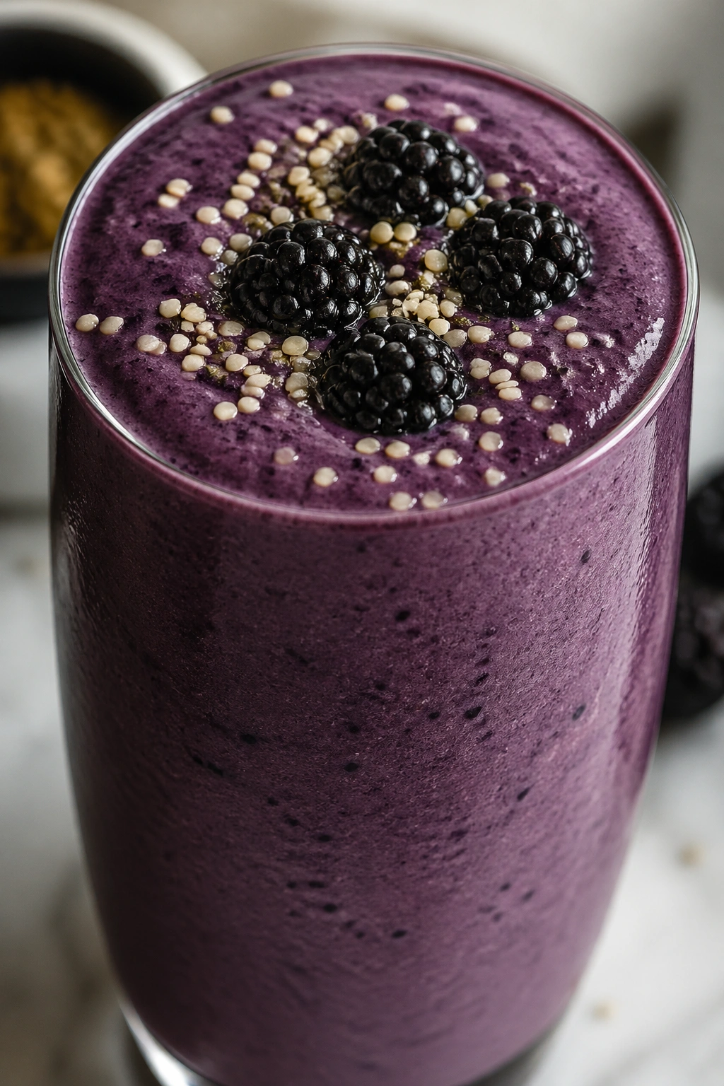 Close-up of Blackberry Vanilla Hemp Smoothie in a glass on a kitchen counter