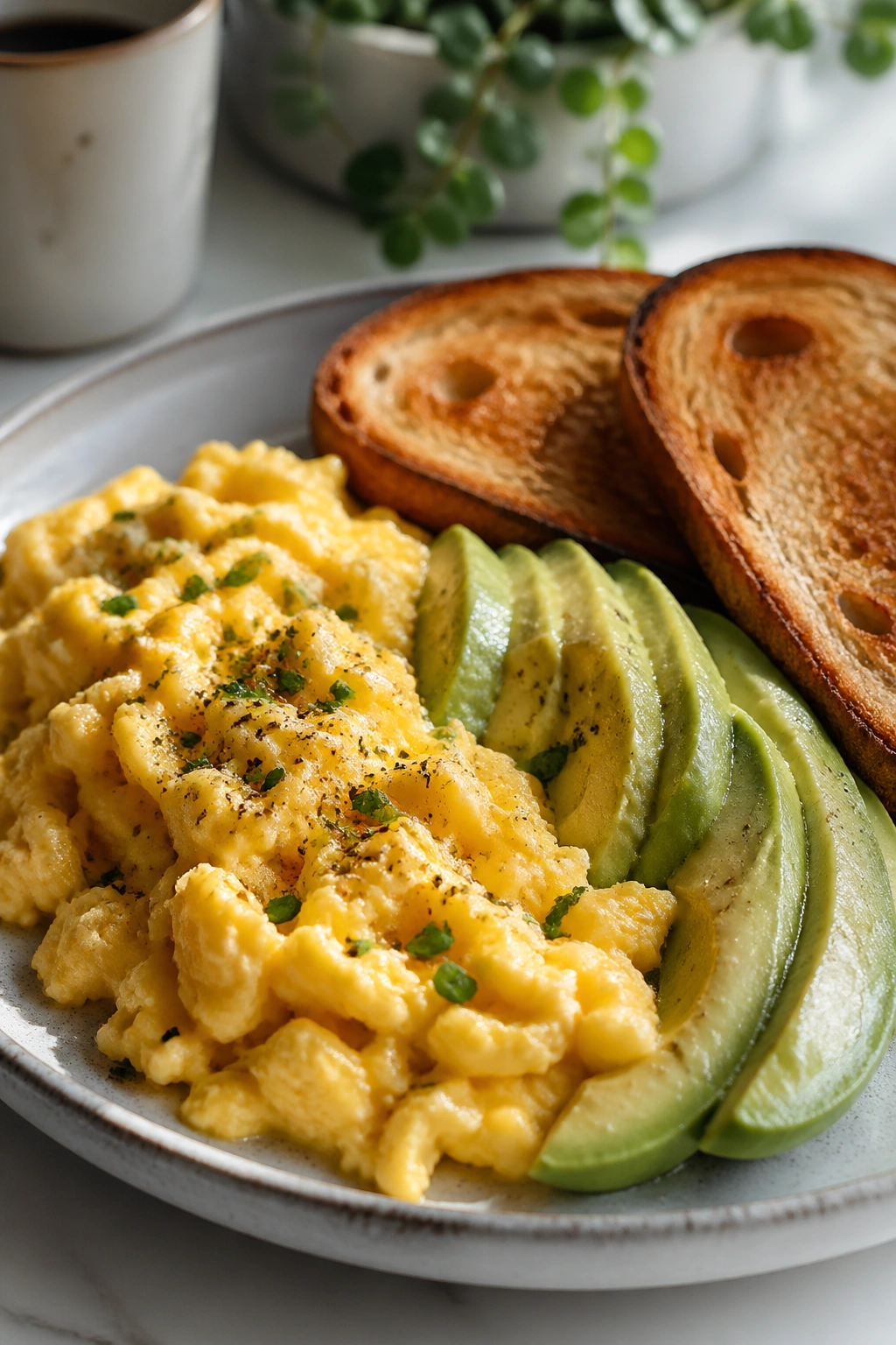 Close-up of a balanced breakfast plate with eggs, avocado, and toast.