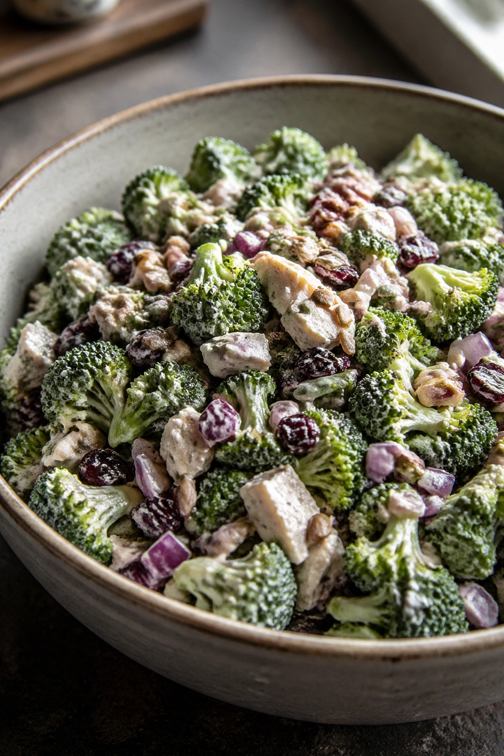 Close-up of broccoli crunch salad with yogurt dressing in a bowl, showing chopped broccoli and toppings.