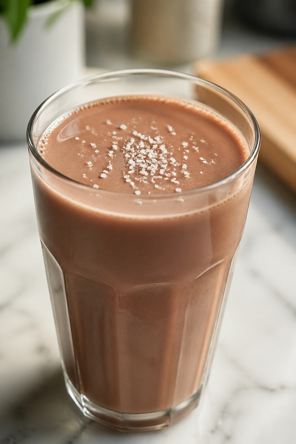 Glass of chocolate milk with a pinch of sea salt on top