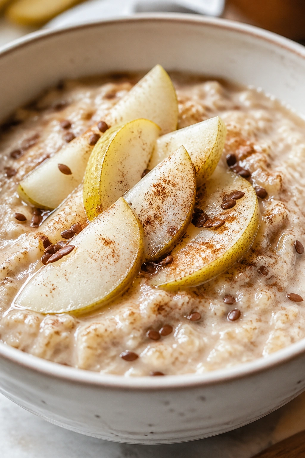 Close-up of egg-white oatmeal with pear and cinnamon in a bowl