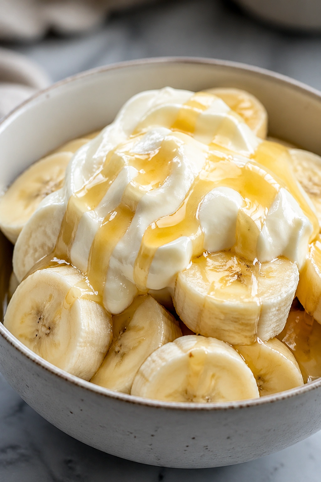 Frozen banana slices with Greek yogurt and honey in a bowl