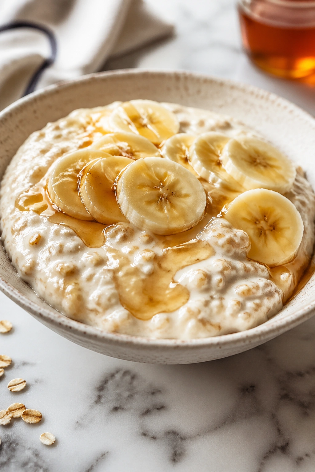 Bowl of Greek yogurt oats with banana and honey for post-workout recovery.