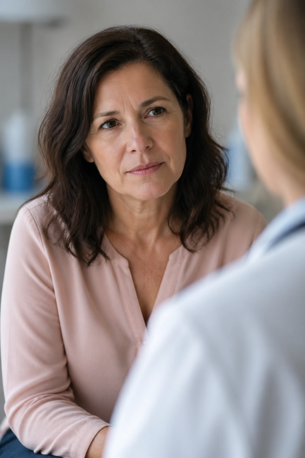 Thoughtful woman in a soft-lit setting representing hormonal health