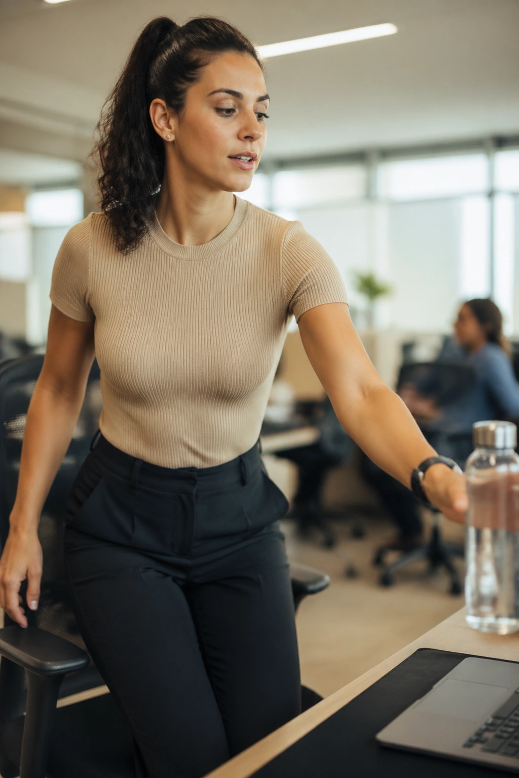 Person standing up from desk to refill water in an office