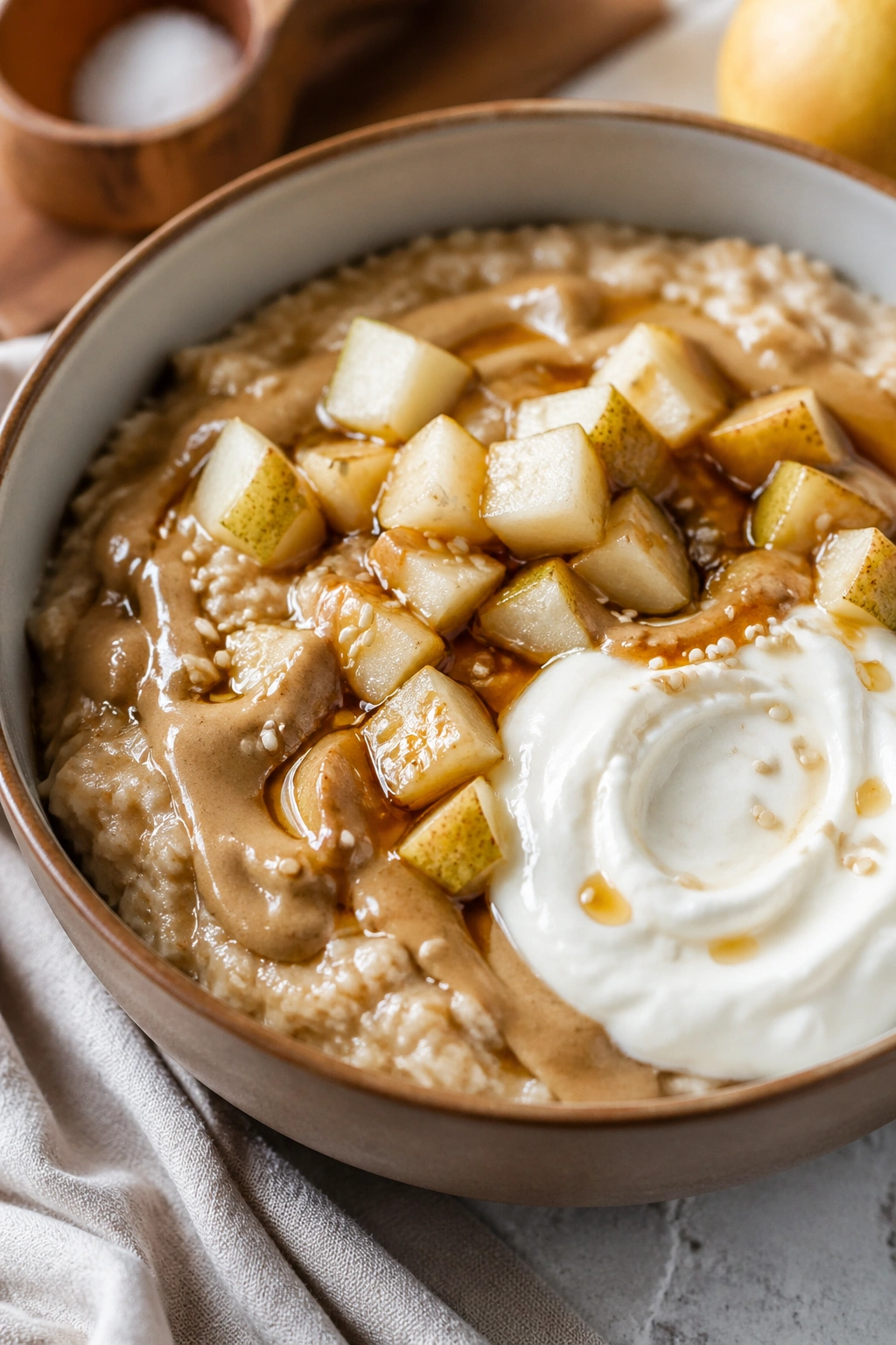 Oats with pear and tahini swirl in a warm kitchen setting