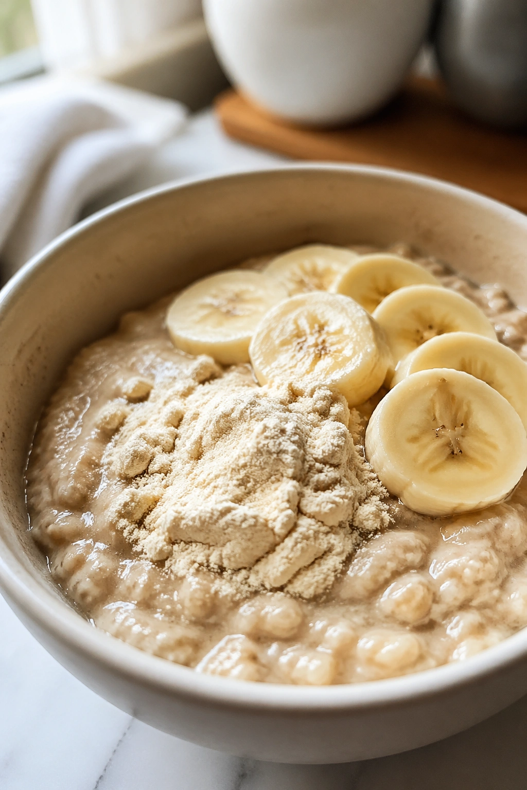 Close-up of oatmeal with banana and whey in a cozy kitchen