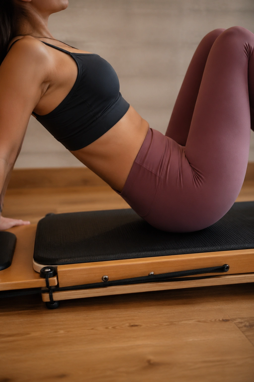 Real person on a Pilates board showing a mild misalignment to illustrate common beginner mistakes.