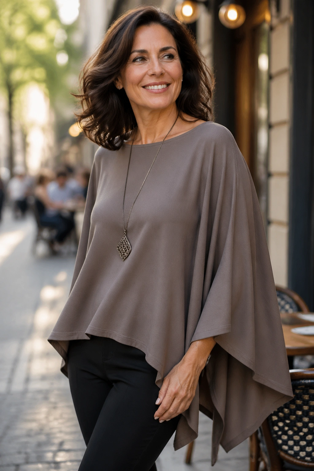 Three-quarter view of a woman wearing a poncho style top with batwing sleeves