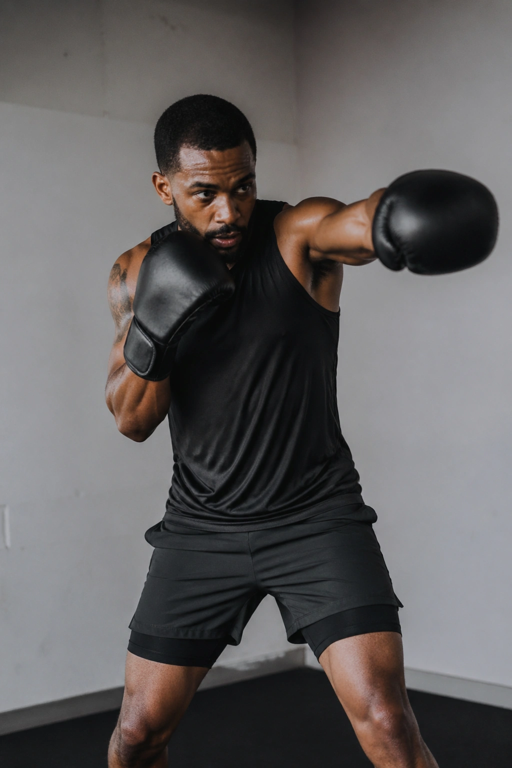 Person shadowboxing in a small gym space with intense focus