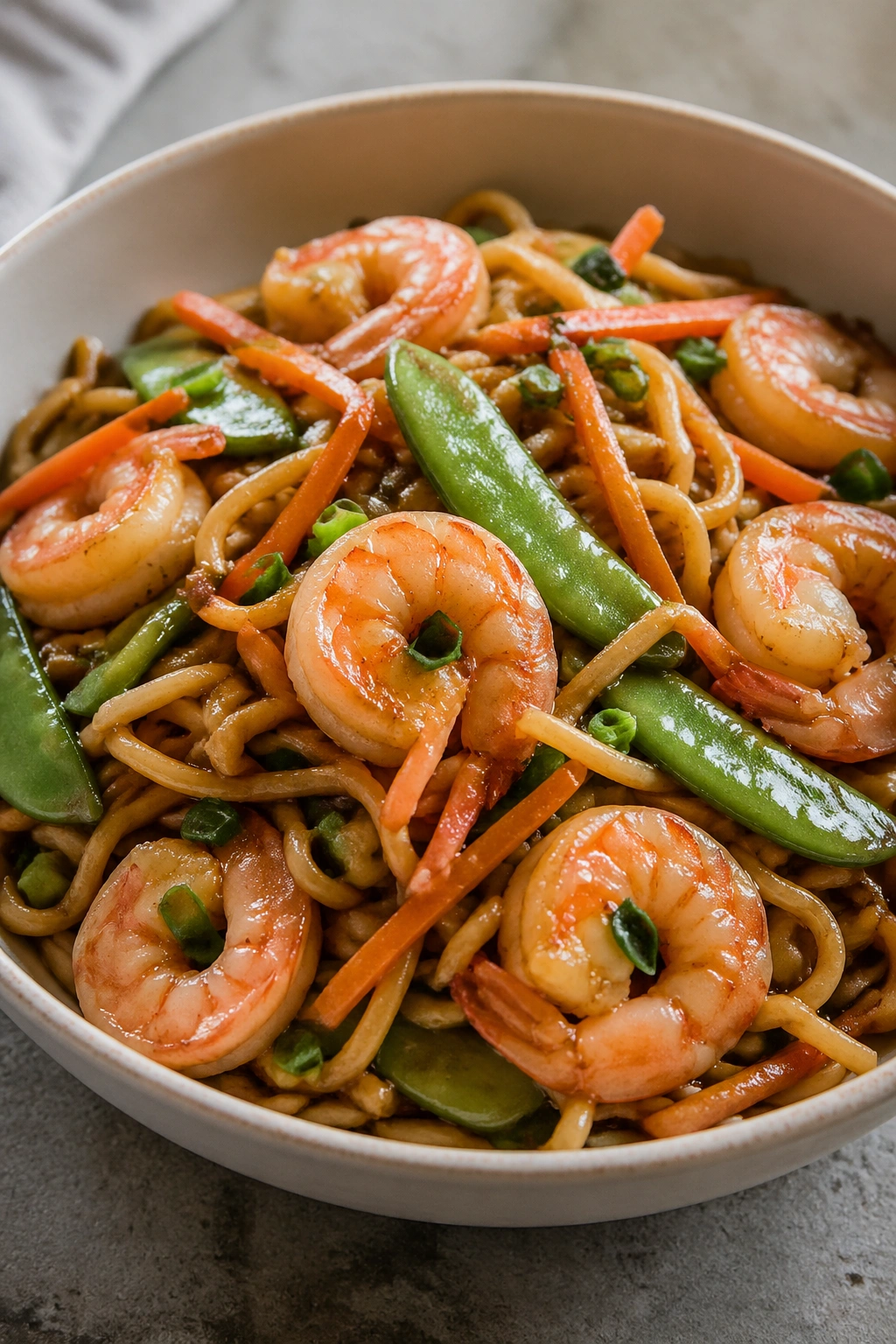 Close-up of shrimp stir-fry noodles with vegetables in a bowl