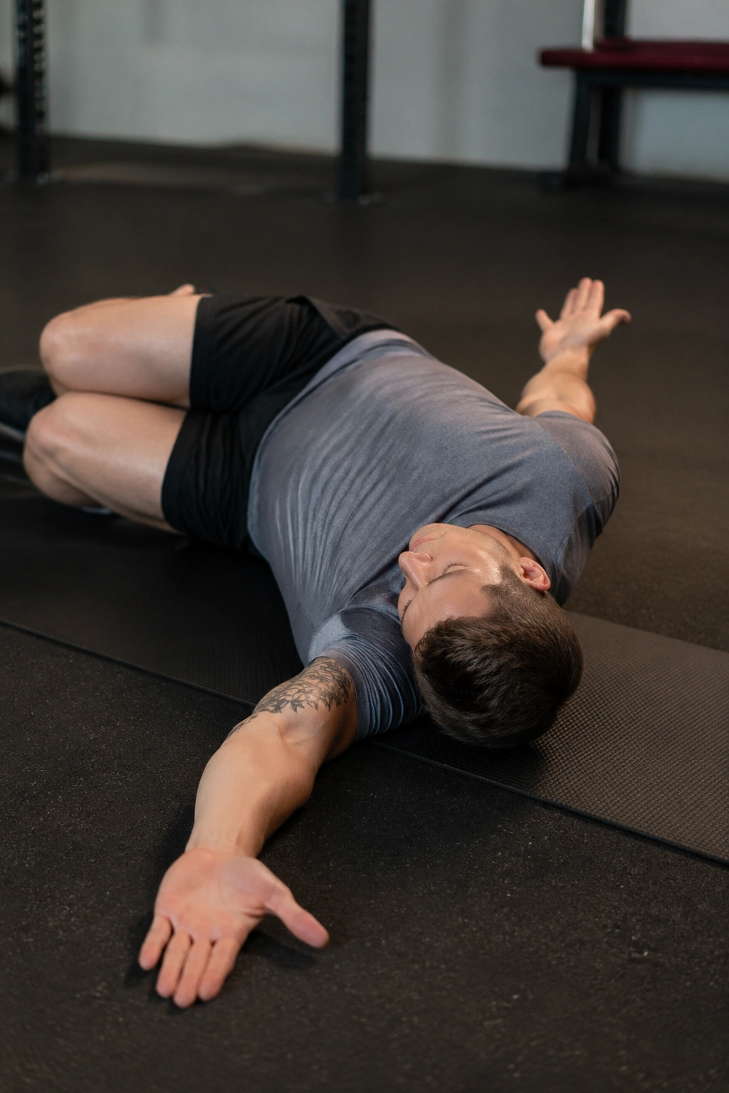 Side-lying thoracic rotation open books on a gym mat, top arm rotating across the body.