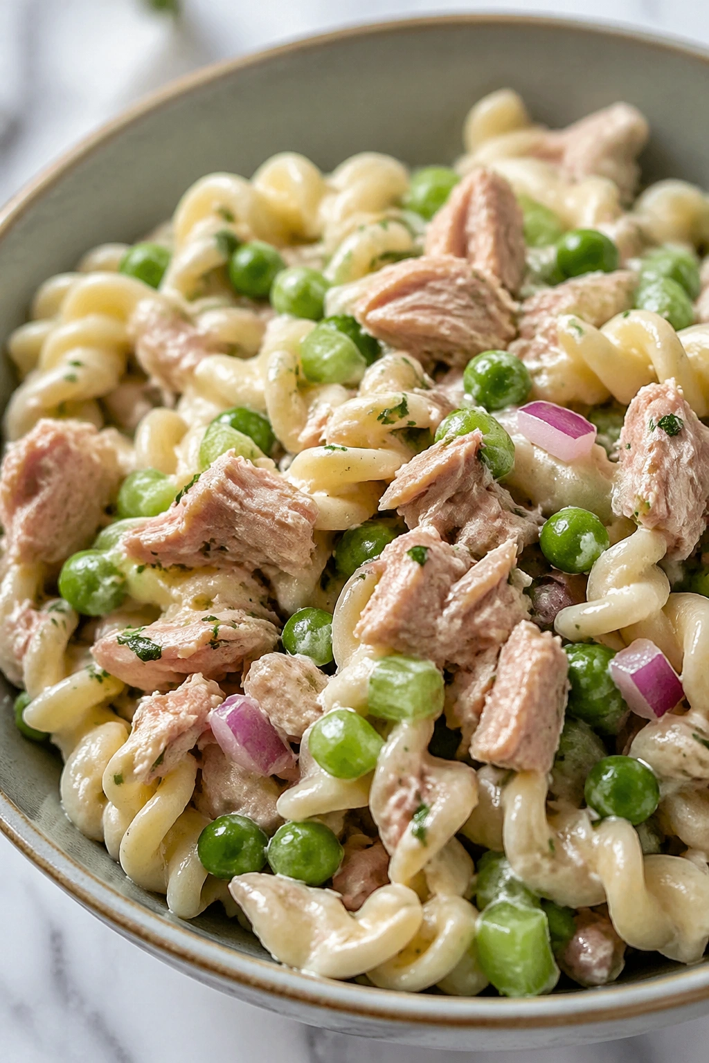 Close-up of tuna pasta salad in a bowl on a kitchen counter