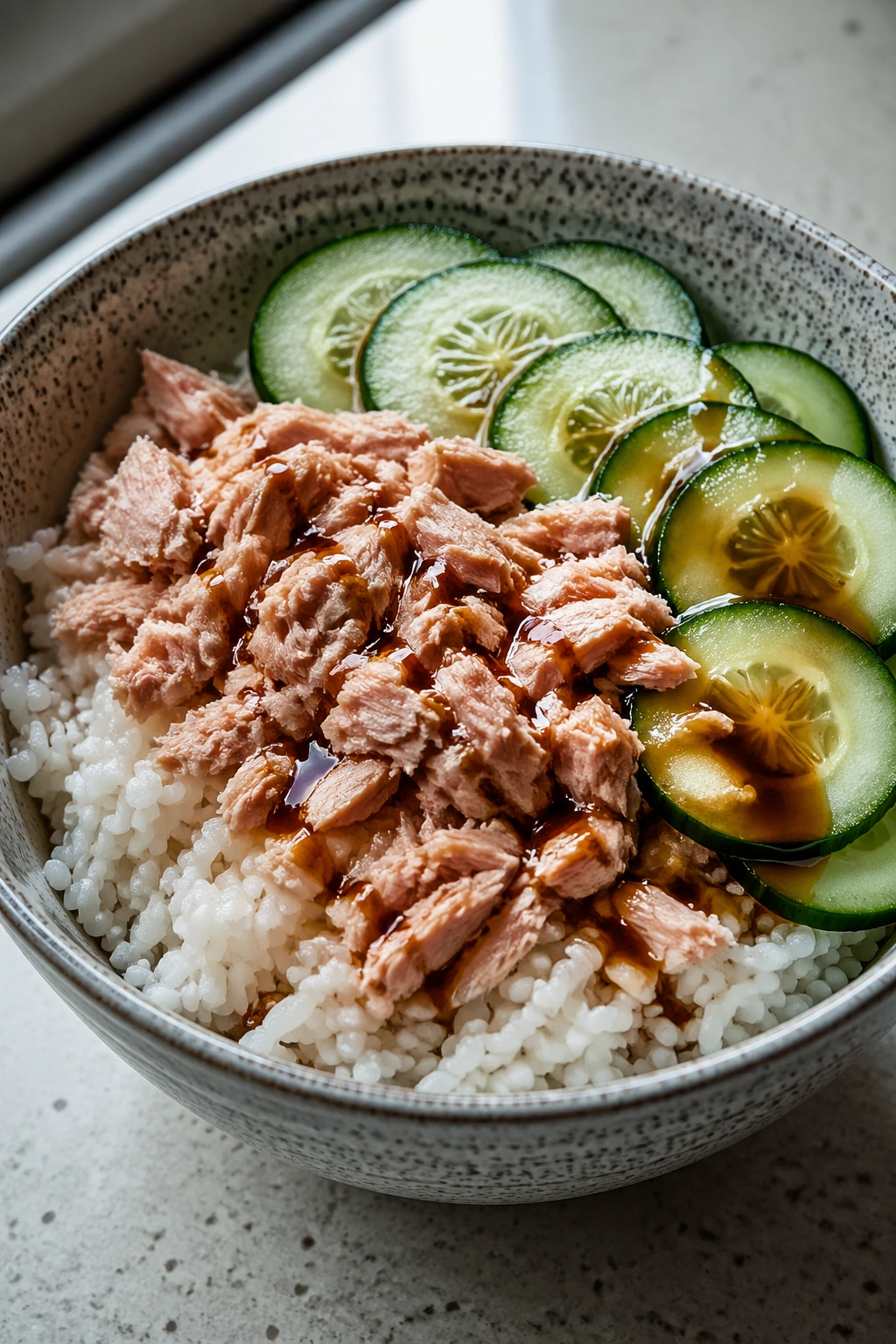 Close-up tuna rice bowl with cucumber and soy sauce