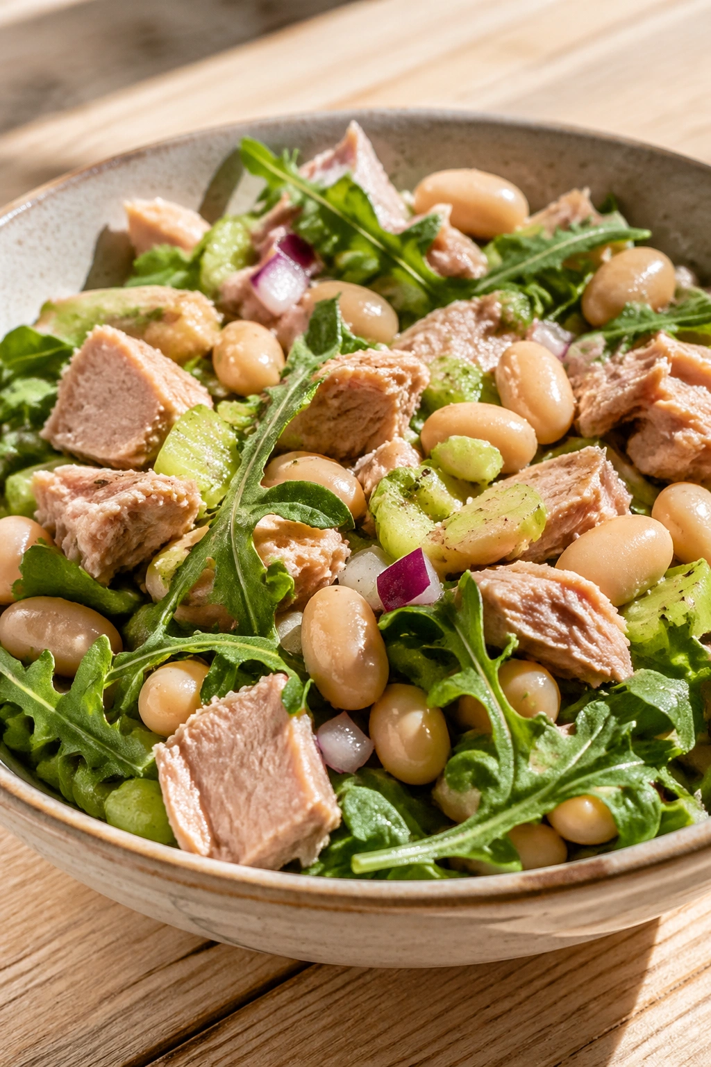Close-up of Tuna White Bean Arugula Salad on wooden table