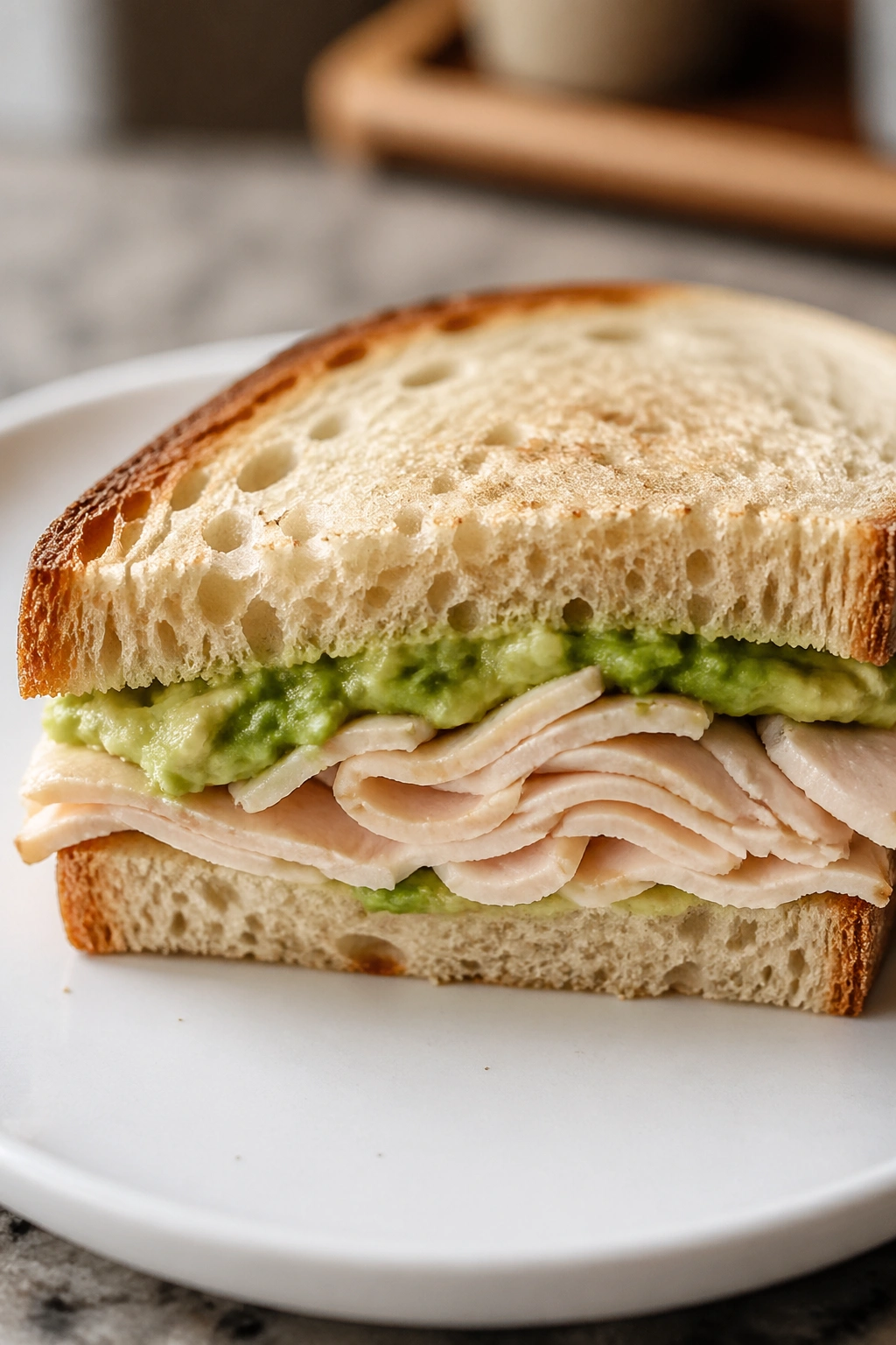 Close-up of turkey and avocado sandwich on sourdough bread.