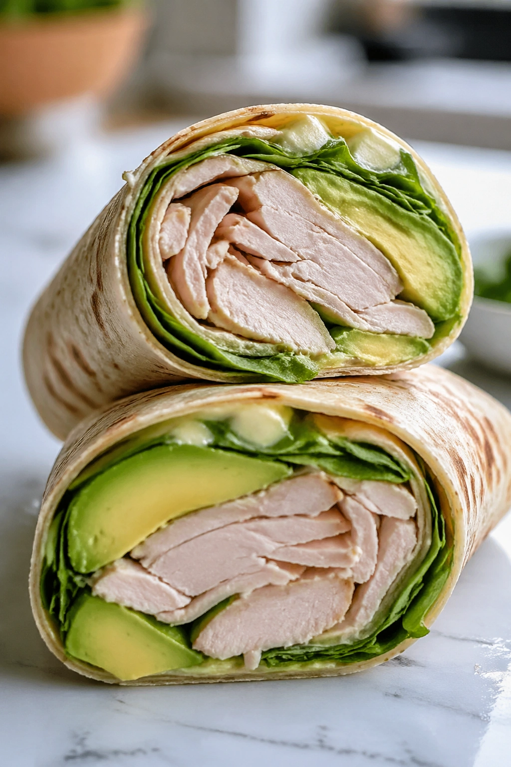 Close-up of turkey avocado wrap cross-section on kitchen counter