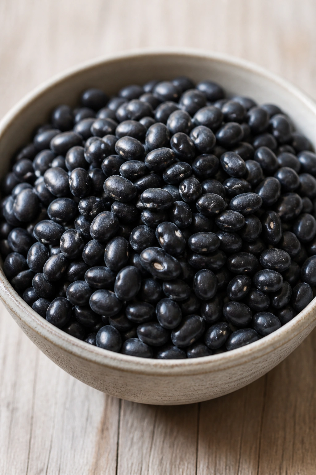 Close-up of black beans in a bowl on a wooden surface