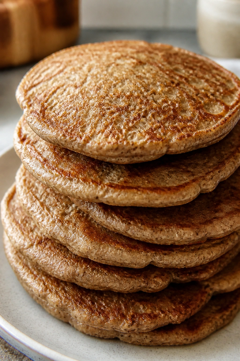 Stack of buckwheat pancakes on plate in a sunny kitchen
