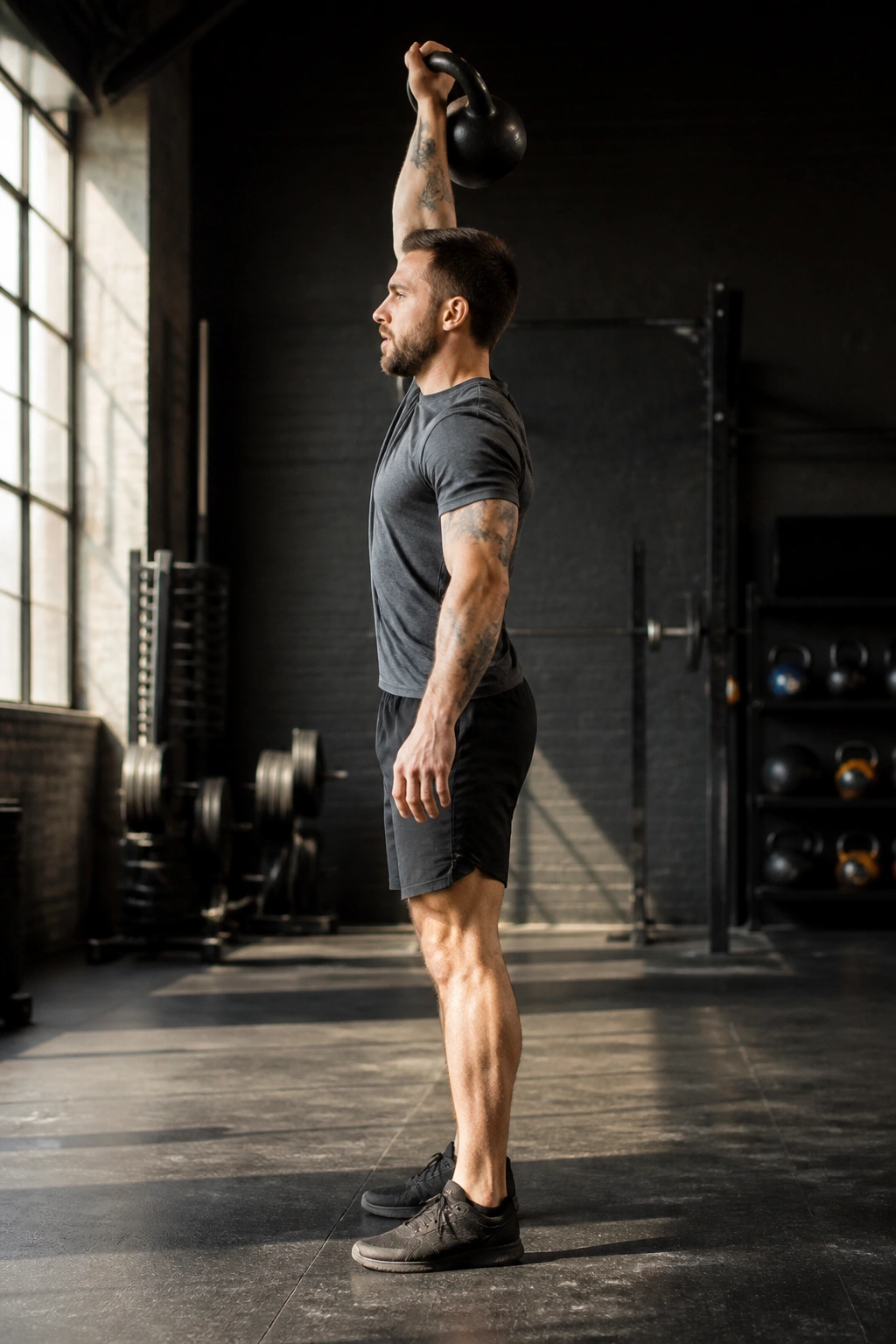 Single-arm kettlebell clean and press during AMRAP in gym