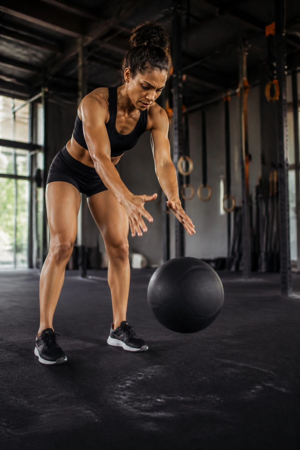 Person performing a medicine ball slam in a gym with strong core engagement