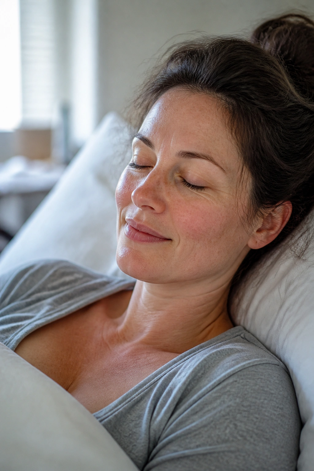 Postpartum mother resting in a softly lit bedroom, emphasizing healing over exercise
