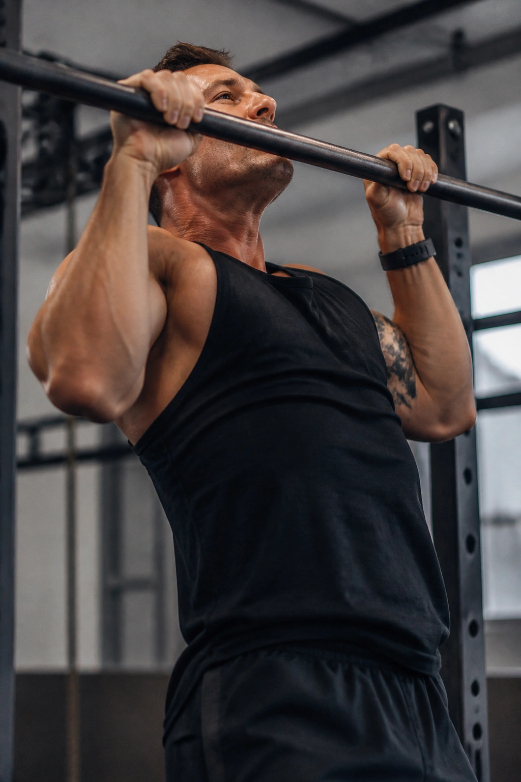 Close-up of a person performing a pull-up on a gym bar.