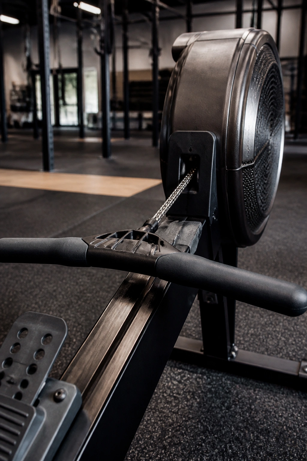 Close-up of rowing machine handle and chain dominating the frame