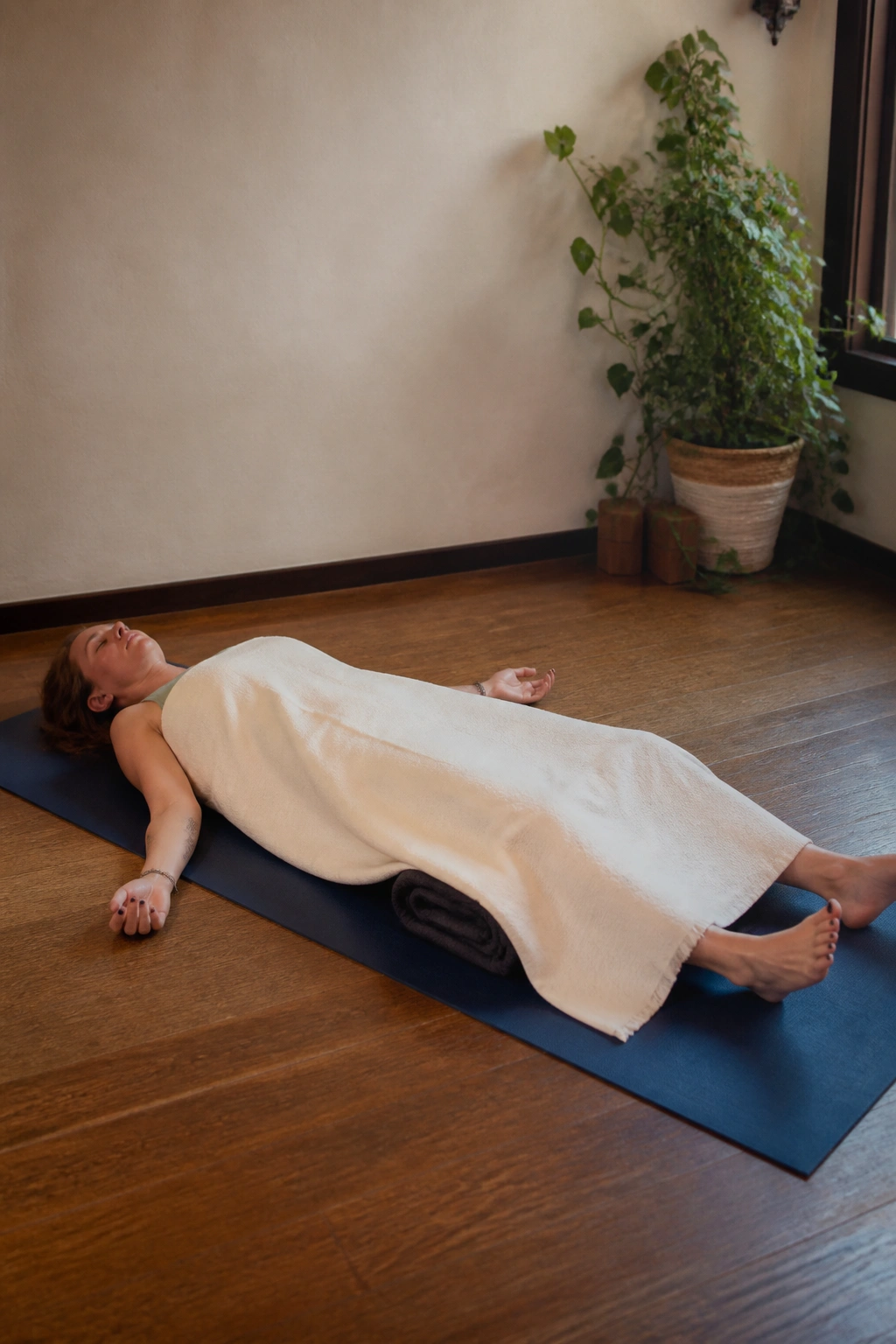 Person in Savasana with blankets at home
