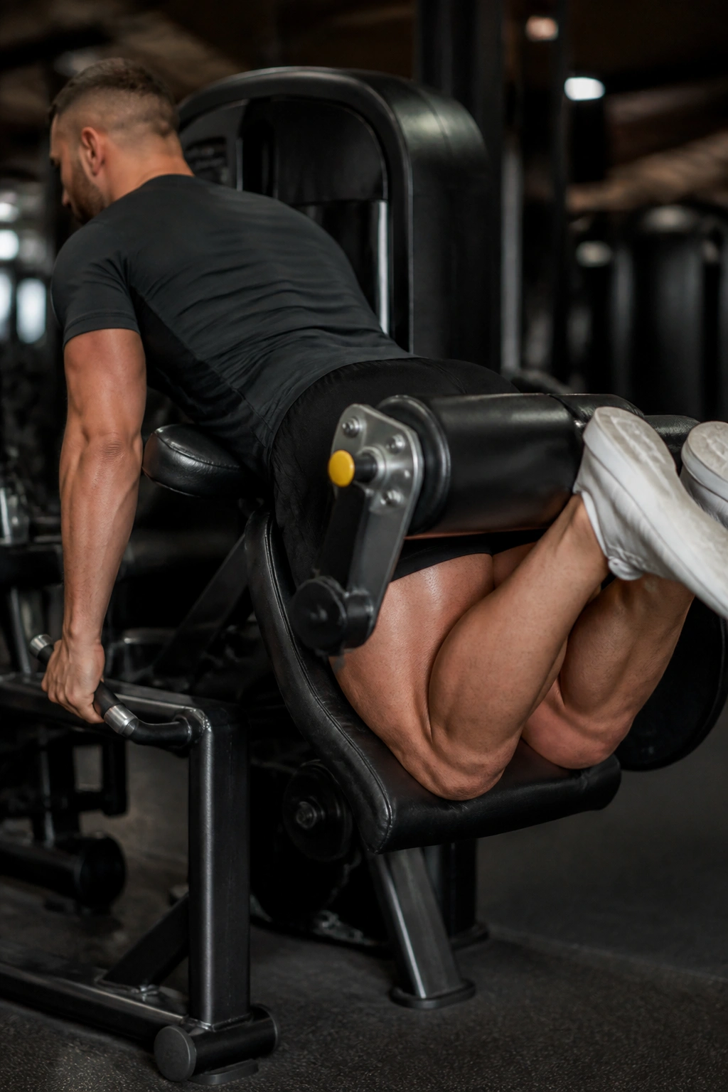 Person performing seated leg curl on leg curl machine emphasizing hamstrings