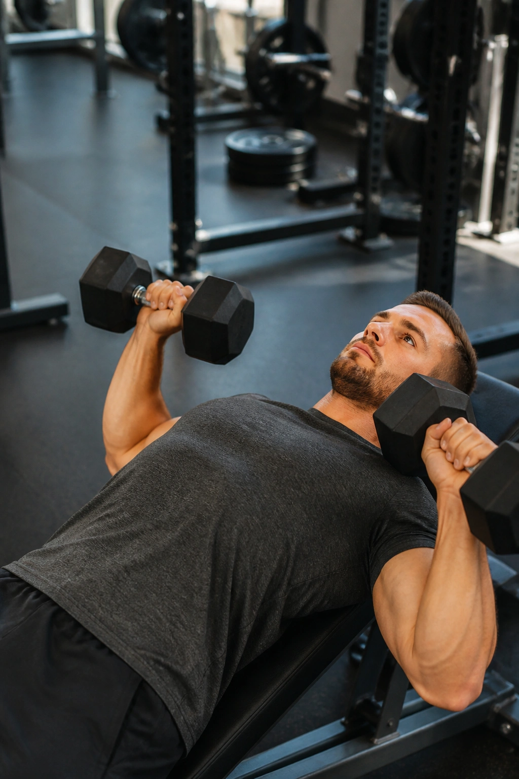 Medium close-up of a lifter performing neutral-grip dumbbell press in a gym, shoulder-friendly upper body workout