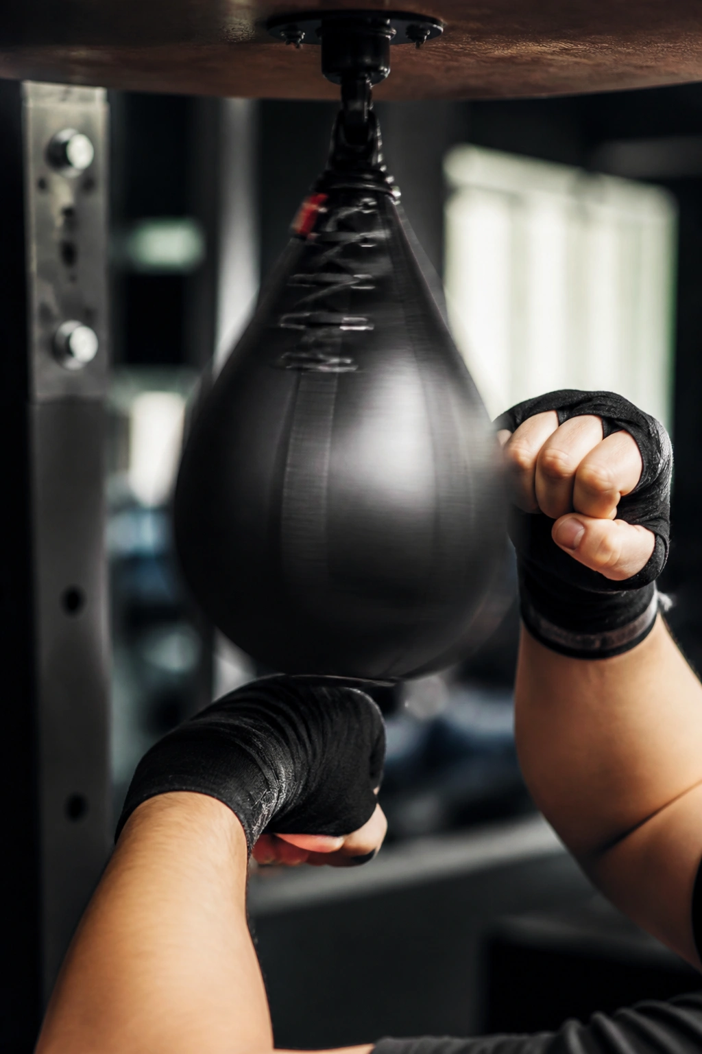 Hands striking a speed bag in a gym during interval focus