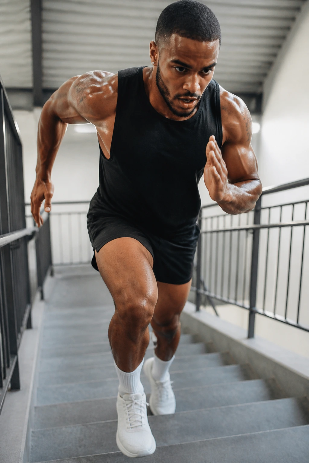 Person sprinting up a short staircase with fast strides in a gym stairwell
