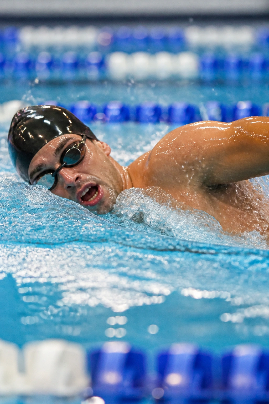 Swimmer performing an interval lap in a pool with splashing water