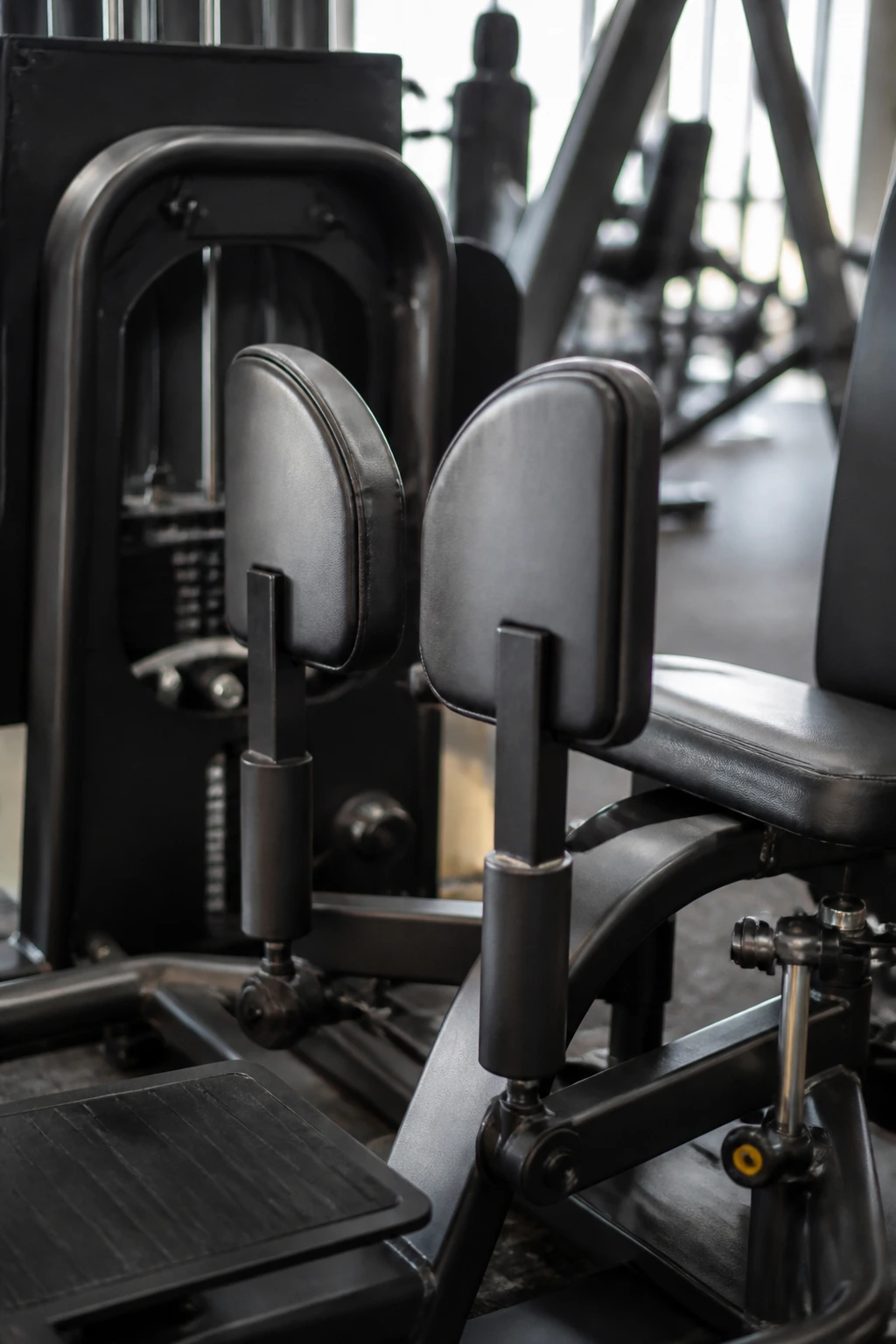 Close-up of abductor machine outer hip pads in gym