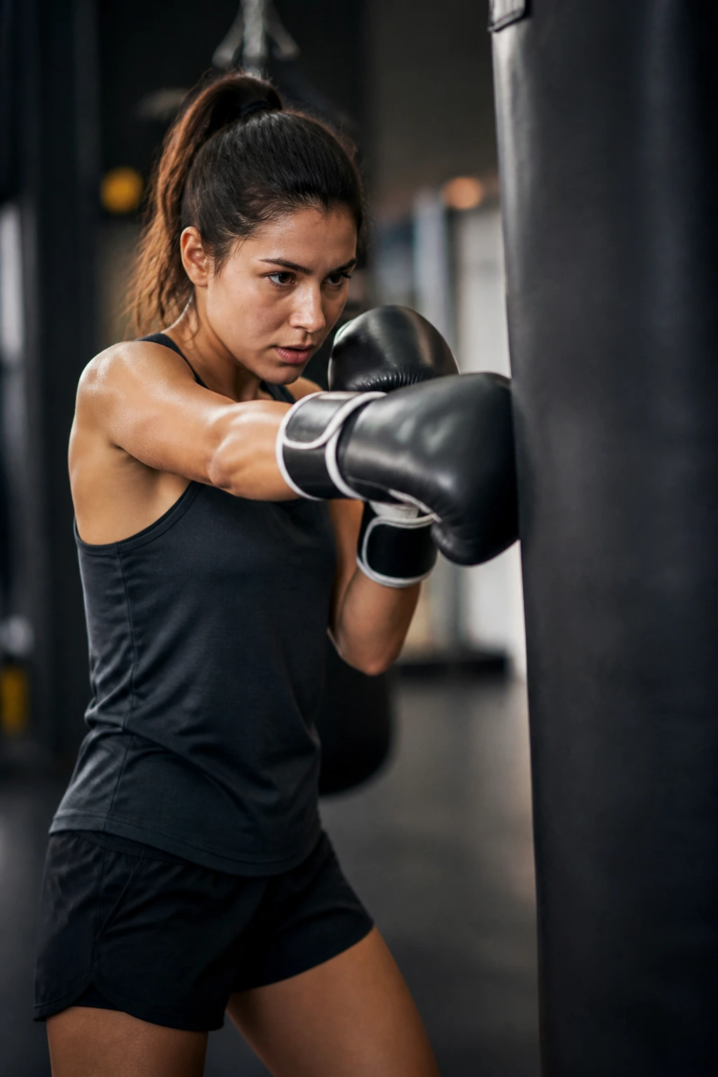 Person performing light punches on heavy bag in gym