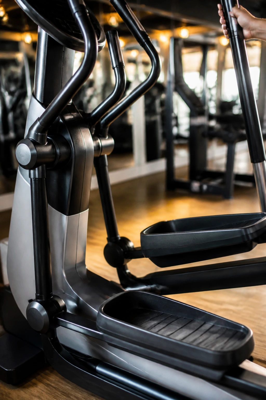Elliptical trainer in a gym with pedals and moving handles