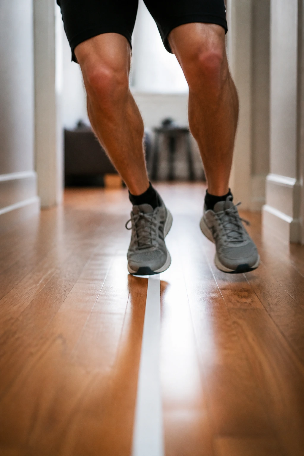 Feet rapid-fire drills crossing a taped line in a hallway.