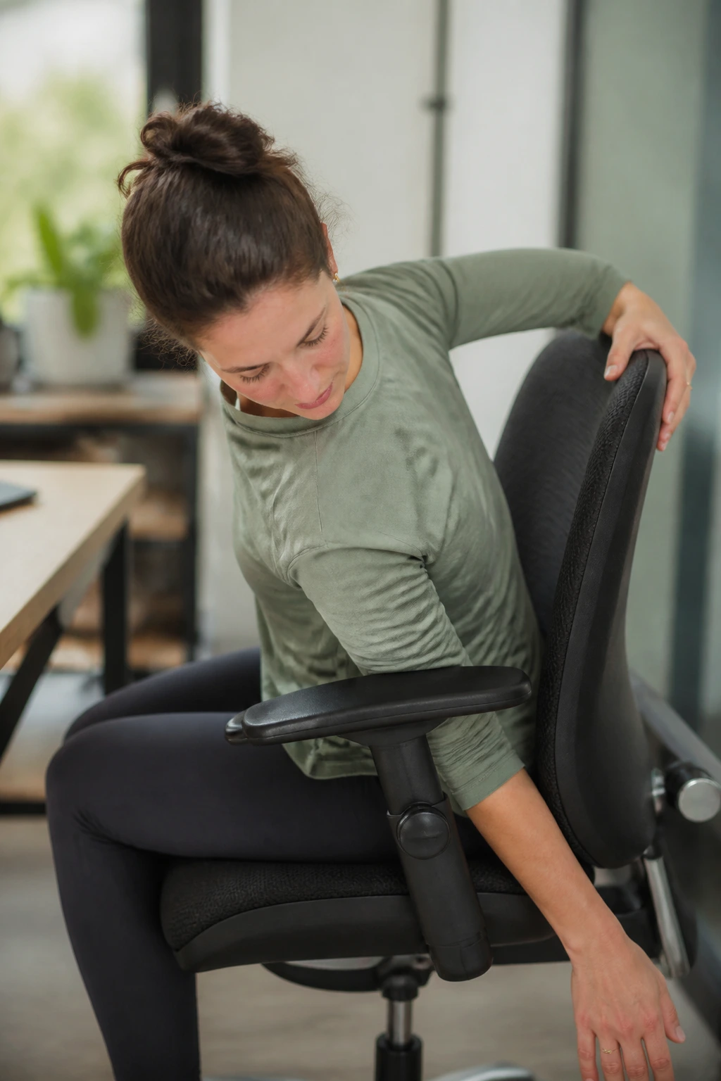Real person performing Seated Thread the Needle stretch at a desk