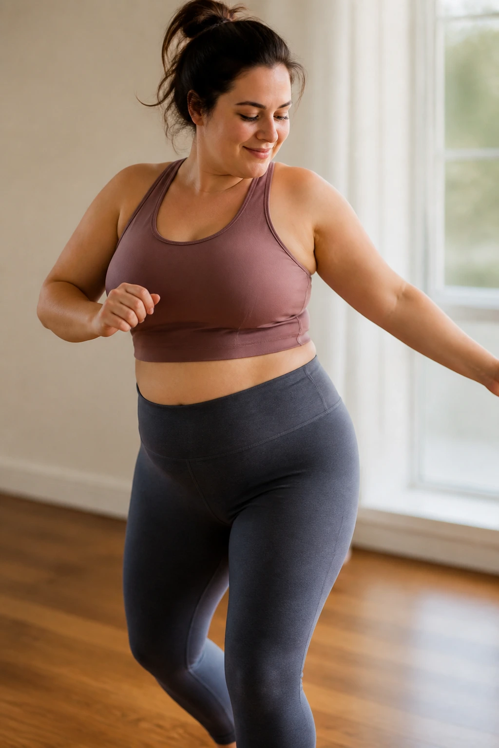 Close-up of a postpartum mom dancing in a cozy living room, low-impact moves