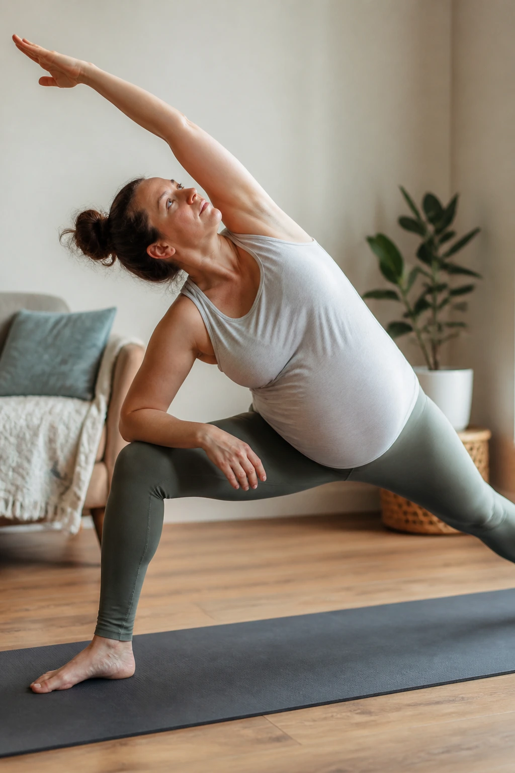 Pregnant woman in Extended Side Angle With Forearm Support performing prenatal yoga with forearm on thigh.
