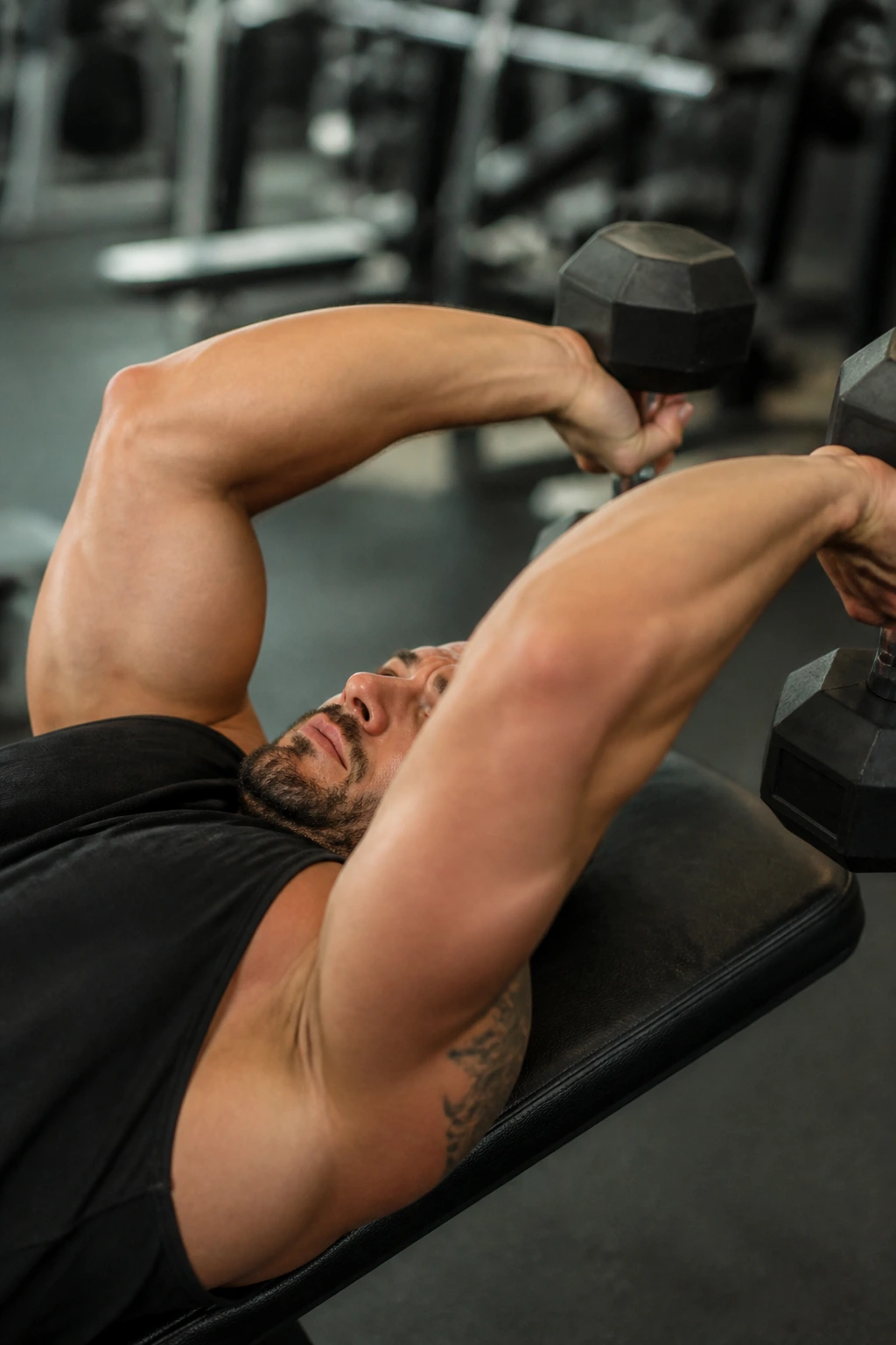 Lying dumbbell skull crusher focusing on elbow stability.