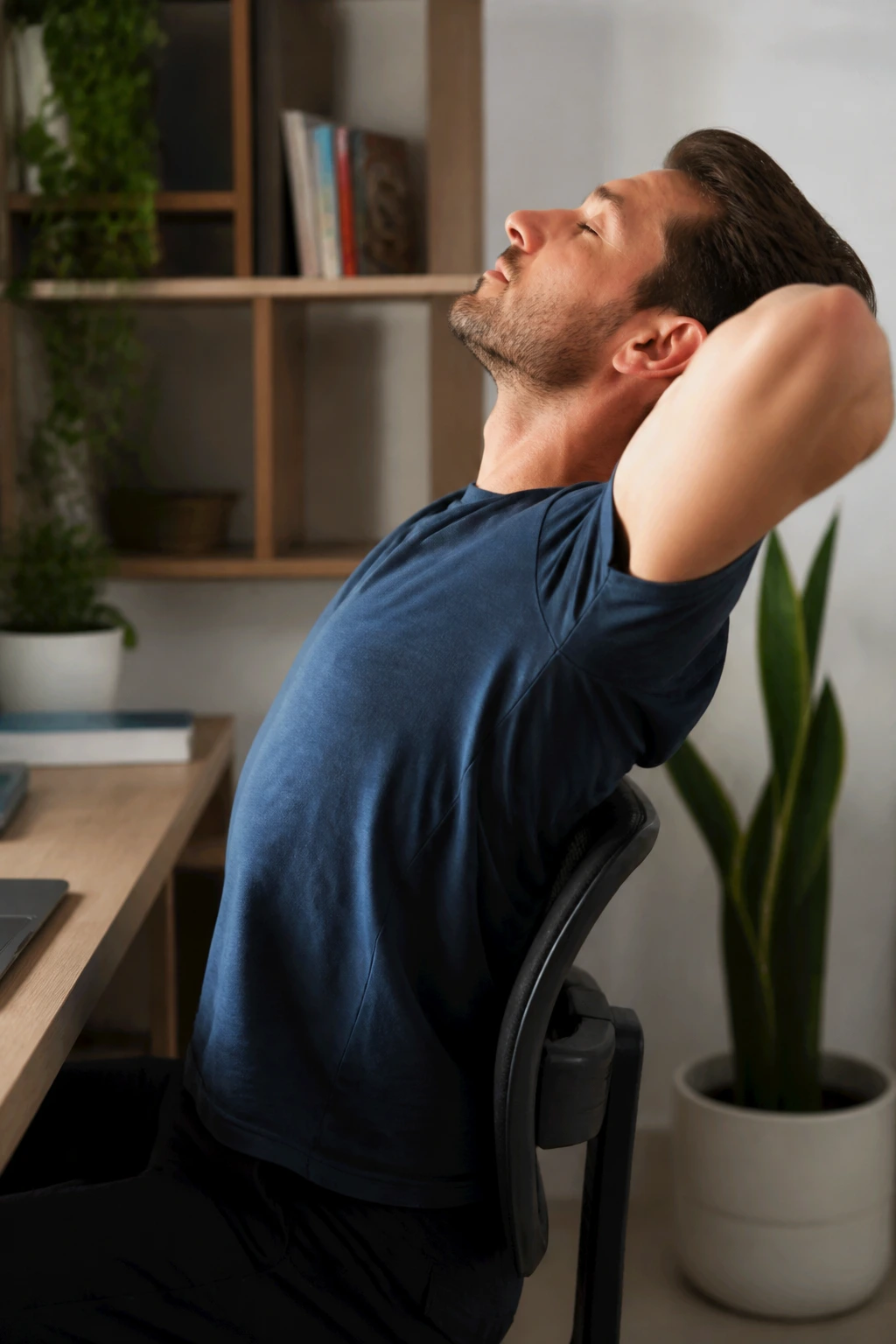 Person performing thoracic extension on a chair in a home office