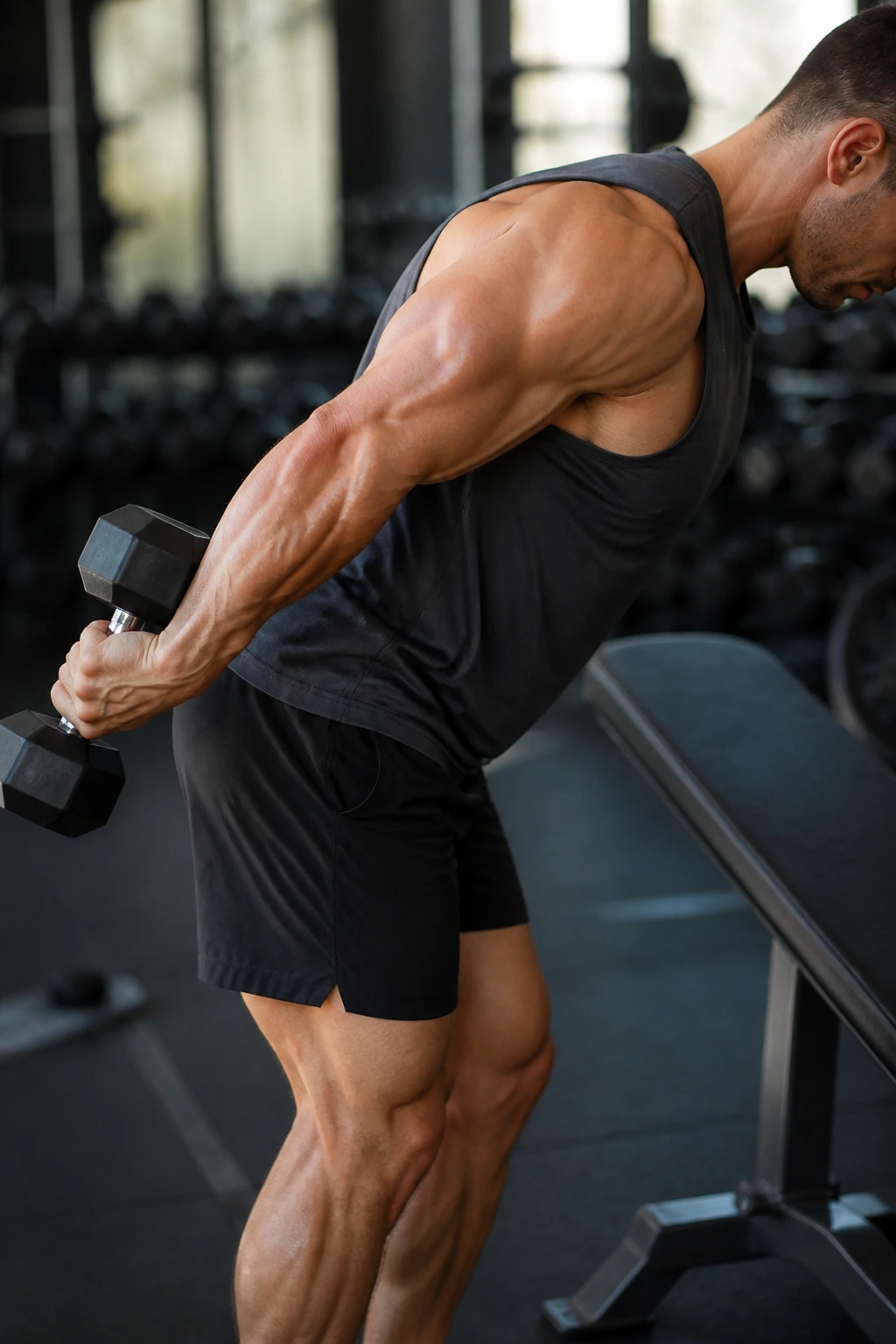 Close-up of a real person performing triceps kickbacks with precise form in a gym